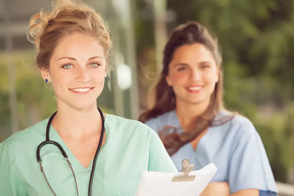 Enfermera sonriente con estetoscopio, representando profesionalismo en cursos de enfermería online.